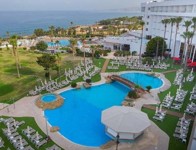 Schattiger Pool neben Hotelgebäude am Meer im Familienurlaub Paphos