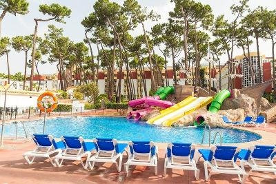 Pool mit bunten Wasserrutschen und hohen Bäumen im Familienurlaub Marbella
