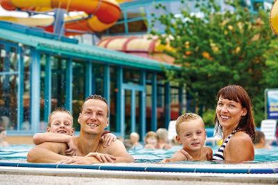 Familie im Außenbereich eines Schwimmbades im Familienurlaub Ostsee