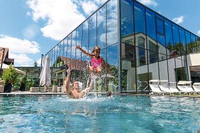 Vater und Tochter haben Spaß im Pool im Familienurlaub Bayern