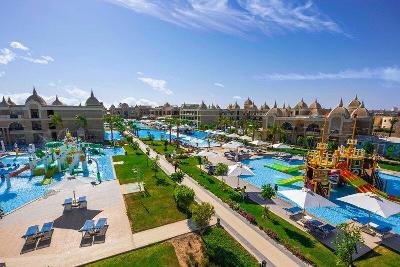 Viele Pools und bunte Wasserrutschen umgeben von Hotel und Wiesen im Familienurlaub Ägypten