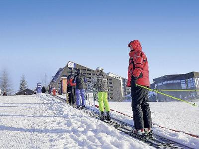 Personen auf einem Skilift im Winterurlaub Erzgebirge