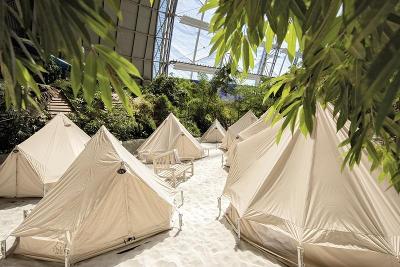 Weiße Zelte auf Sand innerhalb der Kuppel des Tropical Islands im Familienurlaub Brandenburg