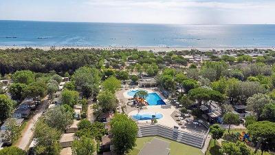 Poolanlage mit Wasserrutschen umgeben von Bäumen nahe dem Meer im Familienurlaub Italien