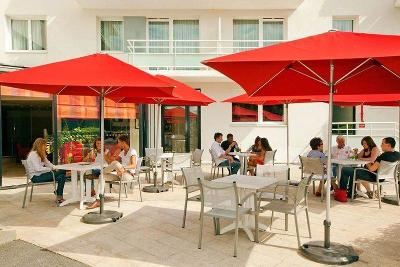 Terrasse mit roten Sonnenschirmen im Familienurlaub Paris
