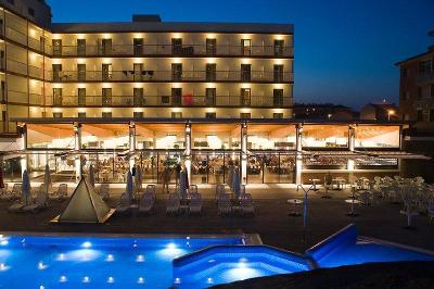Hotelanlage bei nacht mit leuchtend blauem Pool im Familienurlaub Spanien