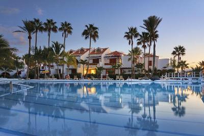 Pool bei Dämmerung in dem sich die Palmen spiegeln im Familienurlaub Kanarische Inseln