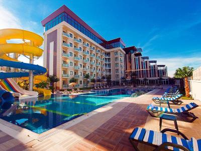 Bunte Wasserrutschen am schattigen Pool mit Liegen im Familienurlaub Türkei