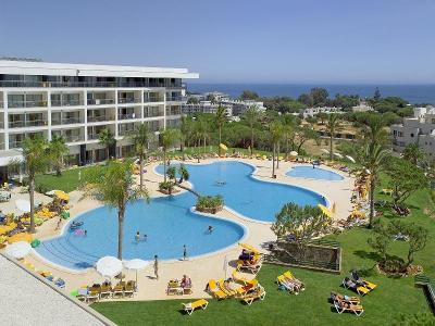 Geschwungene Hotelanlage mit gelben Sonnenliegen im Familienurlaub Portugal