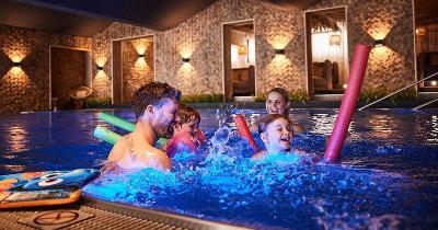 Familie mit Poolnudeln im Hallenbad im Familienurlaub Österreich