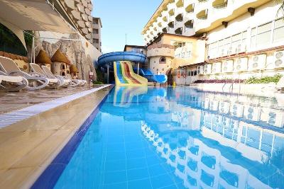 Pool zwischen Hotelgebäuden mit bunten Wasserrutschen im Familienurlaub Türkei