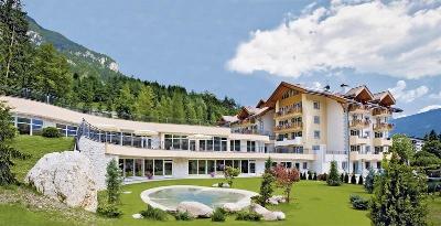 Hotelgebäude vor dem Gebirge mit Teich im Familienurlaub Italien
