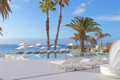 Weiße Sonnenliegen mit Palmen vor dem Ozean im Familienurlaub Gran Canaria
