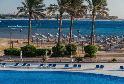 Pool direkt neben dem Strand von Palmen getrennt im Familienurlaub Ägypten