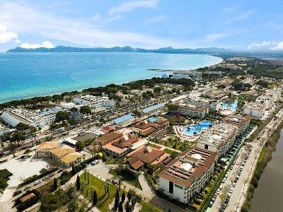 Luftaufnahme von Hotelgebäuden mit Pools unweit vom Strand im Familienurlaub Mallorca