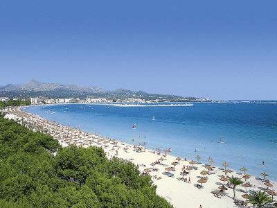 Langer Sandstrand mit Sonnenliegen im Familienurlaub Mallorca