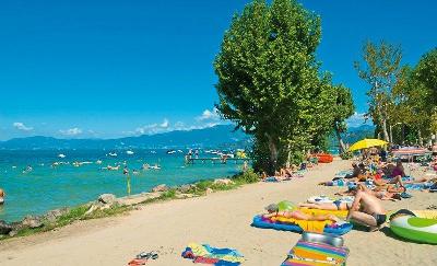 Menschen am Strand mit Badespielzeug im Familienurlaub Gardasee