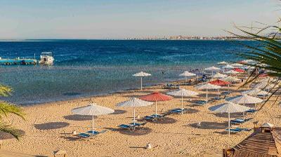 Sonnenliegen mit Schirmen am Meer im Familienurlaub Ägypten