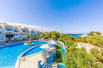 Pool mit kleiner Palmeninsel im Familienurlaub Menorca