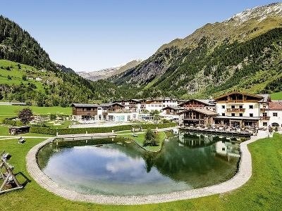 Hotel vor den Bergen mit einem Teich im Familienurlaub Italien