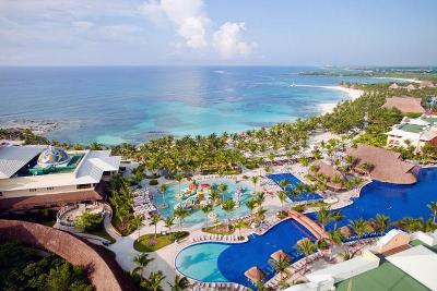 Große Poolanlage mit vielen Palmen direkt am Strand im Familienurlaub Mexiko
