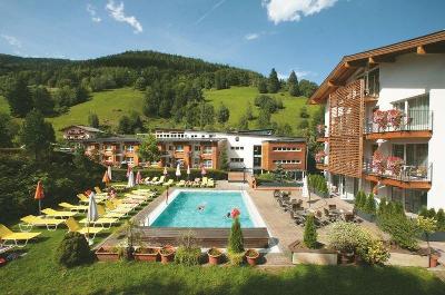 Gelbe Liegen am Pool vor Bergkulisse im Familienurlaub Österreich
