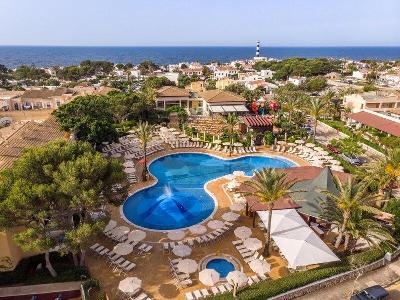 Geschwungener Pool mit Liegen und Schirmen im Familienurlaub Spanien