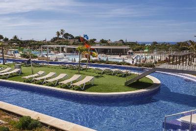 Runder Pool mit Insel auf der Sonnenliegen stehen im Familienurlaub Menorca