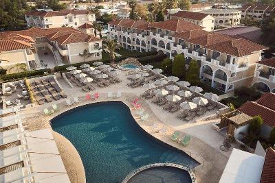 Pool mit Sonnenliegen und Hotelgebäuden im Familienurlaub Griechenland