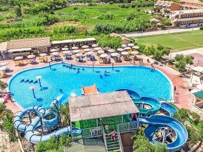 Großer Pool mit zwei blauen Wasserrutschen im Familienurlaub Griechenland