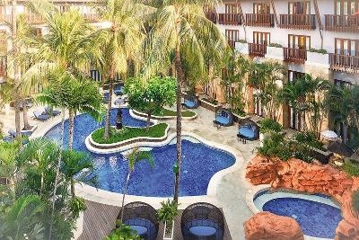 Geschwungener Pool unter Palmen im Familienurlaub Indonesien