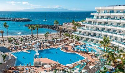 Pool und mehrstöckiges Hotelgebäude direkt am Strand im Familienurlaub Teneriffa