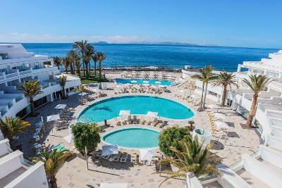 Drei Pools umgeben von Hotel und Palmen im Familienurlaub Kanarische Inseln