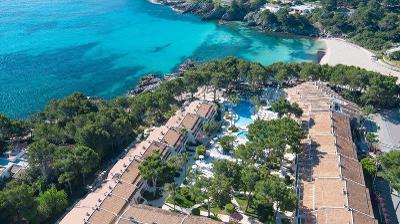 Türkises Meer mit weißem Strand und Hotelkomplex im Familienurlaub Spanien