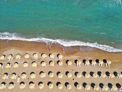 Schöner Strand mit türkis blauem Wasser und Sonnenliegen aus der Vogel Perspektiven