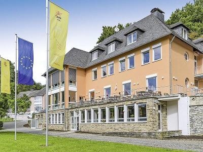 Orangenes Haus mit außen Terasse und drei Flaggen