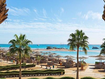 Sonnenschirme am blauen Meer mit Palmen