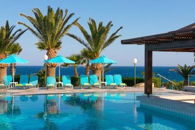 Schöne Poolanlage direkt am Meer mit Sonnenliegen, Sonnenschirmen und Palmen 