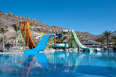 Der Wasserpark mit bunten Wasserrutschen und einem großen Pool im Familienurlaub Spanien
