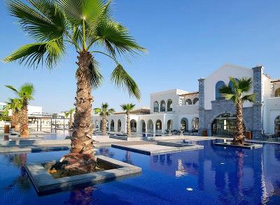 Das Resort mit Palmen und einem großen blauen Pool im Familienurlaub Griechenland