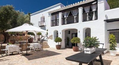 Weiße Finca mit Terrasse und Sonnenschirm im Familienurlaub Ibiza