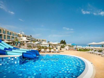Wasserrutschen enden im Pool und Meer im Hintergrund im Familienurlaub Kroatien