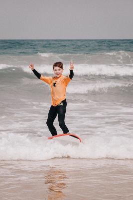 ein Junge steht auf einem Surfboard und reitet die Wellen 