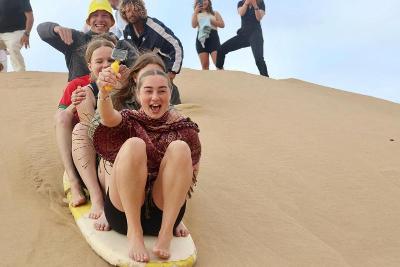 Gruppe von Jugendlichen haben spaß beim Sandboarding, familienurlaub marokko