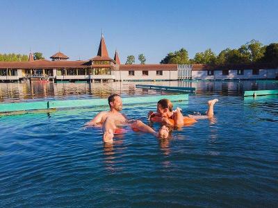 Mutter und Vater baden im Pool im Familienurlaub Ungarn
