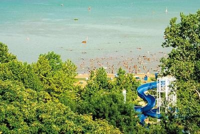 Strand am Balaton mit blauer Wasserrutsche im Familienurlaub Ungarn