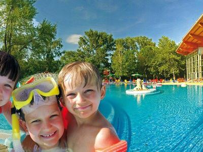 Drei Kinder lächelnd am Pool im Familienurlaub Ungarn