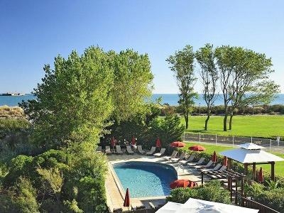 Blick auf die Poolanlage mit Meer im Hintergrund im Familienurlaub Frankreich