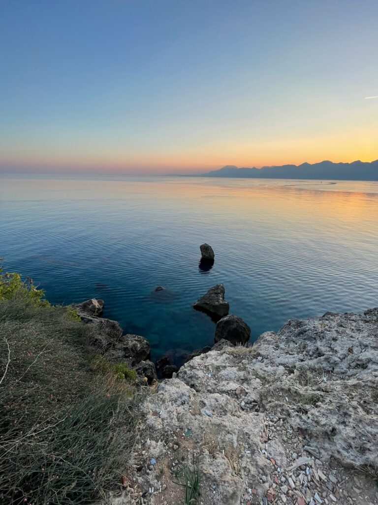 Ausblick auf das Meer vor Antalya mit der Berregion im Hintergrund beim Sonnenuntergang im Türkei Urlaub mit Kindern