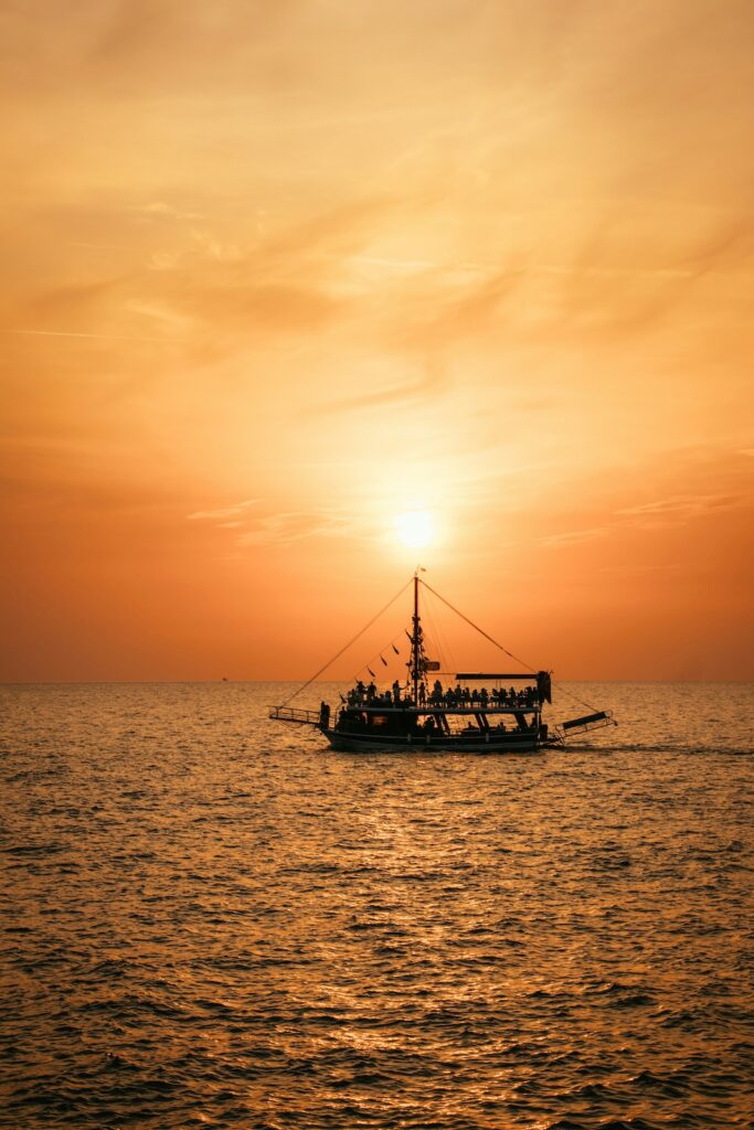 Ein Boot auf dem Meer im orangefarbenen Sonnenuntergang im Türkei Urlaub mit Kindern